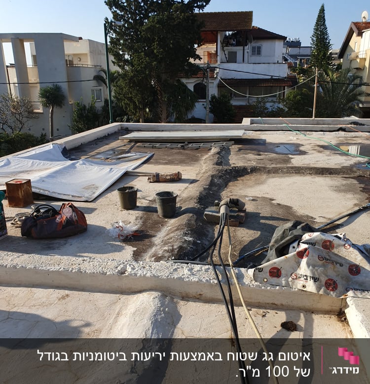 חומרי איטום וכלים על גג שטוח בתהליך עבודה